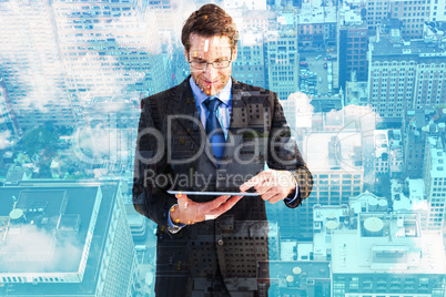 Composite image of businessman standing while using a tablet pc