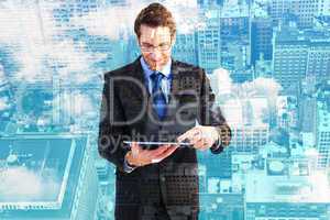 Composite image of businessman standing while using a tablet pc