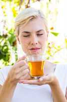 Attractive blonde woman holding glass of tea