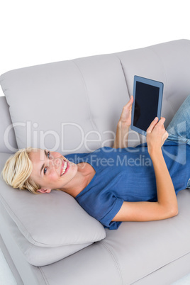 Blonde woman using her tablet on the couch