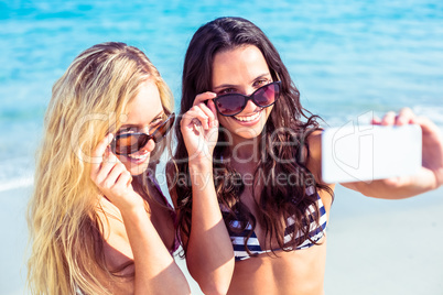 two friends in swimsuits taking a selfie