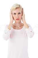 Serious blonde woman covering her ears