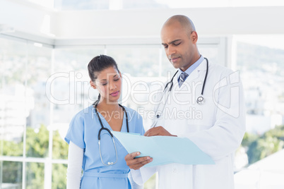 Smiling doctors reading files