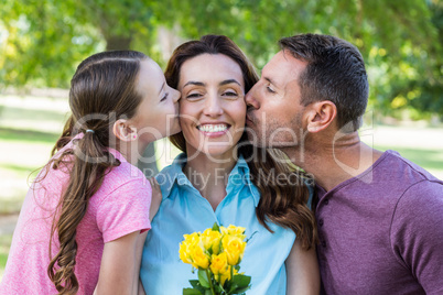 Happy family kissing at camera in the park