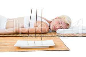 Attractive blonde woman resting on bamboo mat