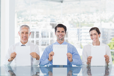 Smiling business team showing paper