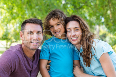 Happy family kissing at camera in the park