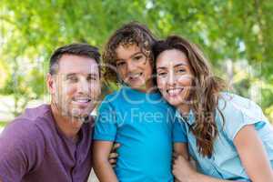 Happy family kissing at camera in the park