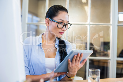 Smiling businesswoman sitting at her desk and working with table