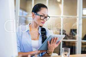 Smiling businesswoman sitting at her desk and working with table