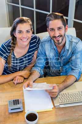 Partners working at desk and smiling at camera