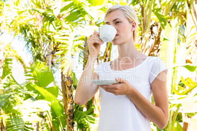 Attractive blonde woman drinking hot beverage