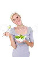 Happy blonde woman holding bowl of salad