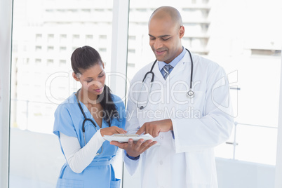 Smiling doctors reading files