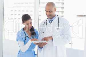 Smiling doctors reading files