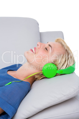 Happy woman listening music on the couch