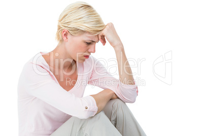 Depressed blonde woman sitting on the floor