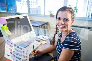 Smiling brunette working with photographs and digitizer