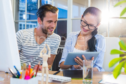 Smiling partners working together on tablet