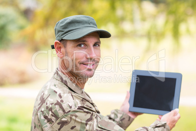 Soldier looking at tablet pc in park