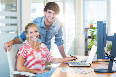 Smiling team working with digitizer and laptop