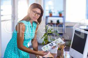 Smiling casual businesswoman working with photos