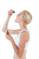 Fit blonde woman swallowing medicine