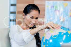 Pretty businesswoman looking at globe