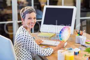 Casual businesswoman working with computer and colour chart
