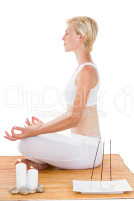 Fit woman meditating on bamboo mat