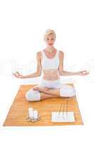 Fit woman meditating on bamboo mat
