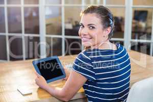 Smiling brunette holding tablet