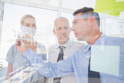 Businessman drawing graph on the glass