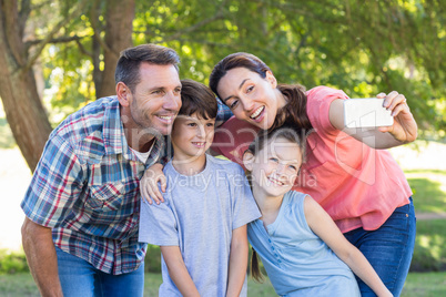 Happy family in the park taking selfie