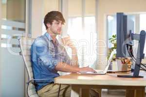 Serious casual businessman sitting at desk