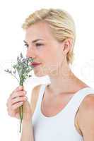 Gorgeous blonde woman smelling flowers