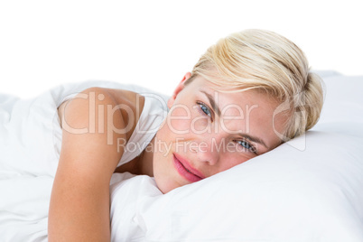 Smiling blonde woman lying in her bed