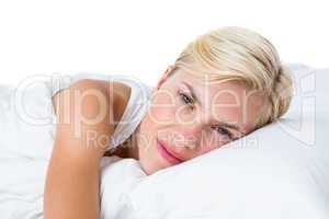 Smiling blonde woman lying in her bed