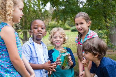 Happy siblings looking at a jar