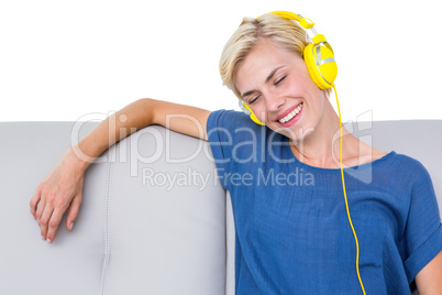 Happy blonde woman listening music