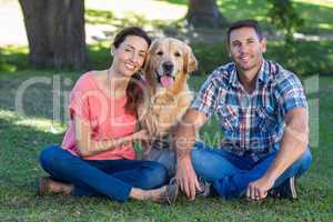 Happy couple with their dog in the park