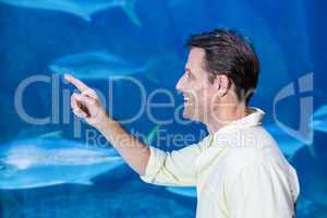 Happy man pointing a fish tank
