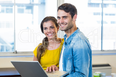 Casual business partners holding laptop