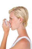 Asthmatic pretty blonde woman using inhaler