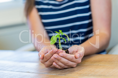 Brunette holding green sprouts