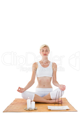 Fit woman meditating on bamboo mat