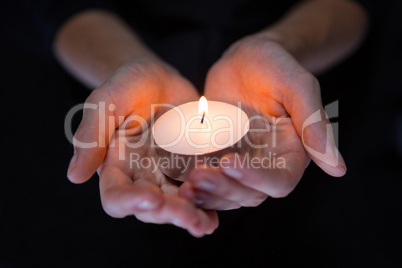 Hands holding candle