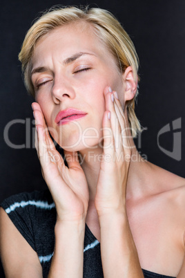 Attractive blonde woman touching her face