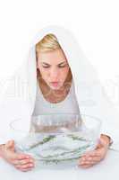 Blonde woman inhaling herbal medicine