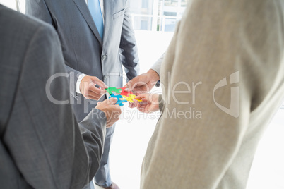 Business colleagues holding piece of puzzle